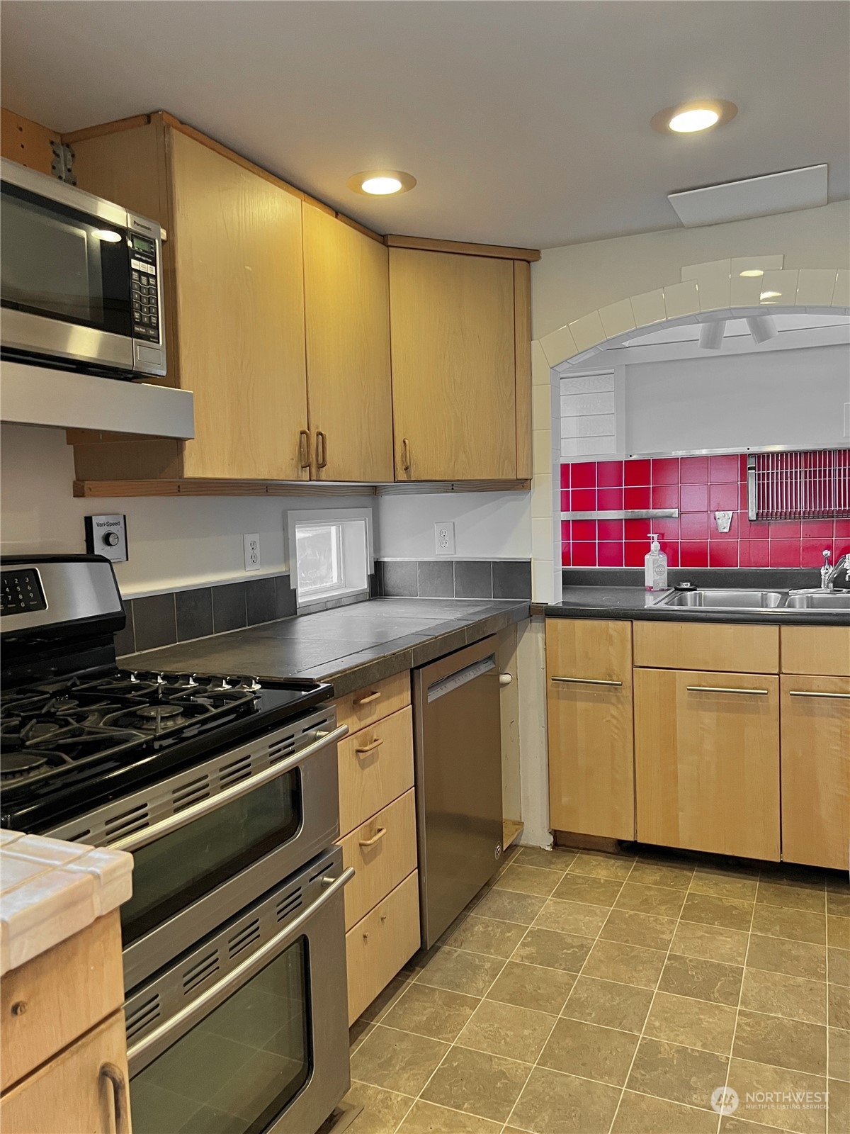 2219 Fairview Avenue East, Unit 11 Seattle, WA 98102 - Photo 7 of 15 a kitchen with granite countertop a stove top oven microwave and cabinets