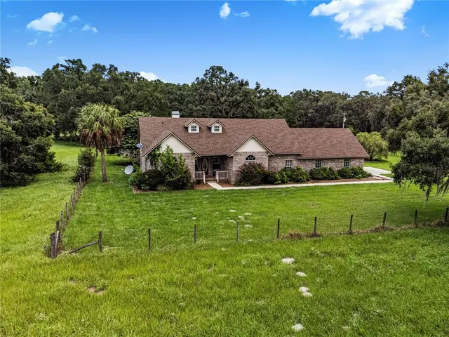 a aerial view of a house next to a big yard