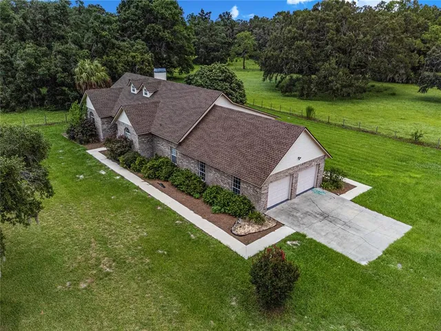 a aerial view of a house with yard and green space