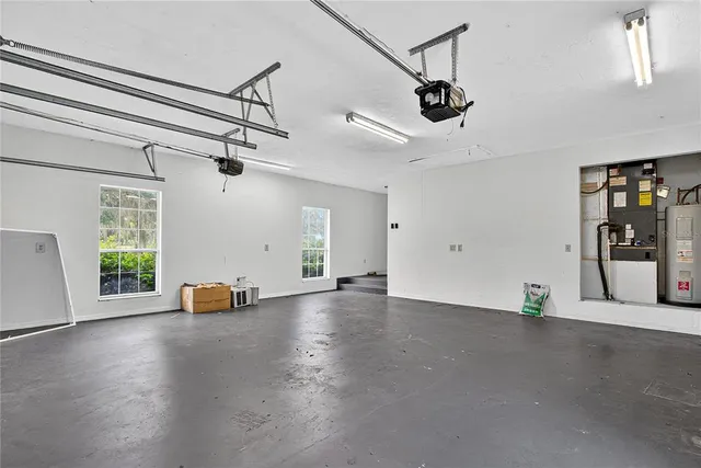 an empty room with windows and ceiling fan