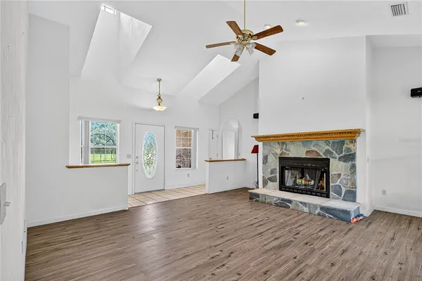 an empty room with windows and fireplace