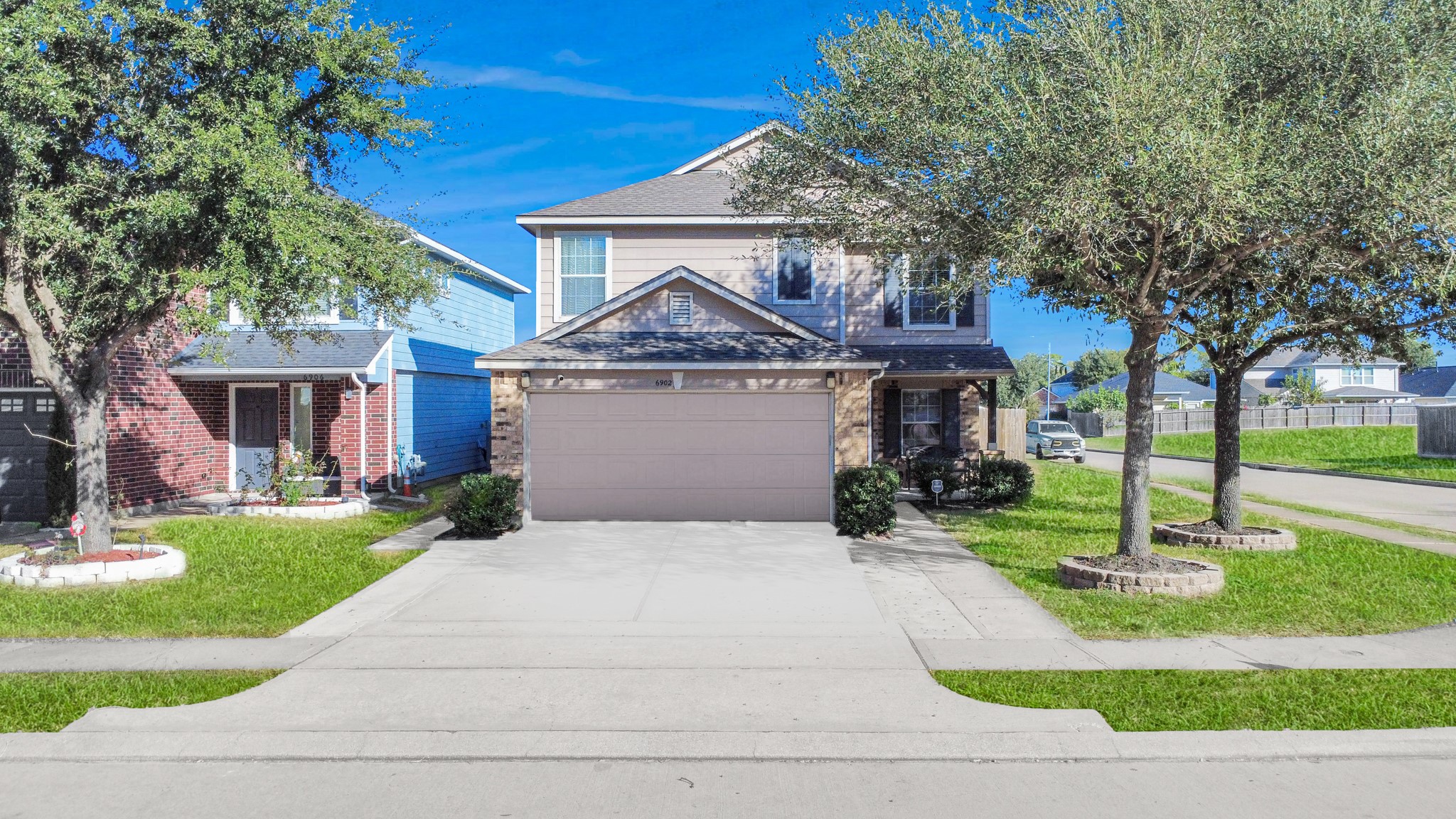 a front view of a house with a yard and trees