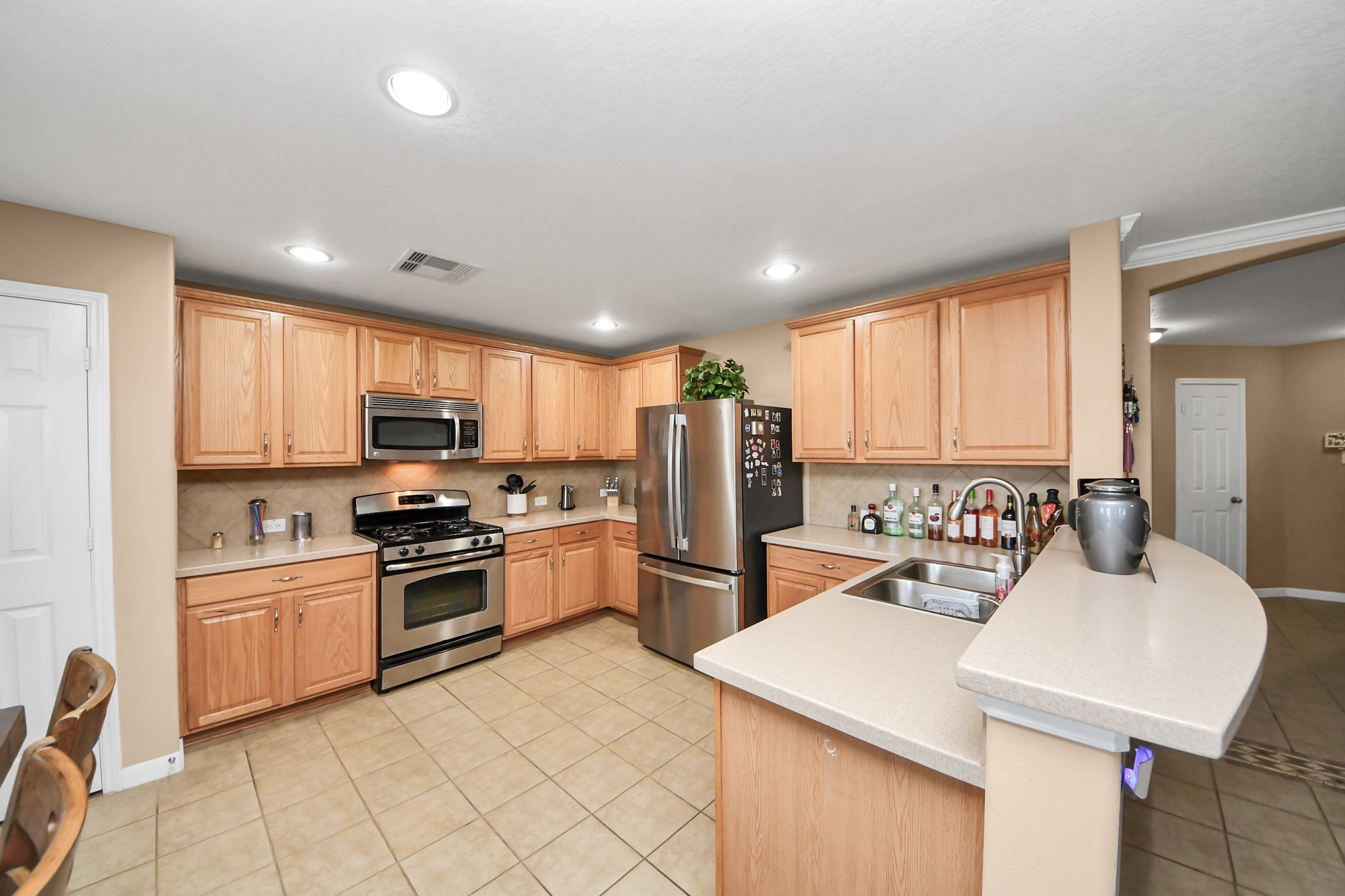 6902 Anson Point Lane Houston, TX 77040 - Photo 7 of 40 a kitchen with stainless steel appliances granite countertop a sink stove refrigerator and cabinets