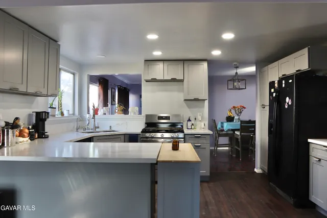 a kitchen with stainless steel appliances granite countertop a sink stove and refrigerator