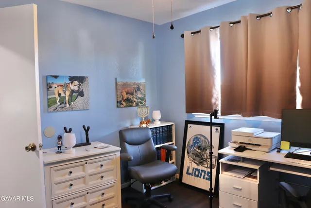 a view of a workspace with furniture and a window