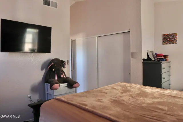 a bedroom with a bed and a flat screen tv