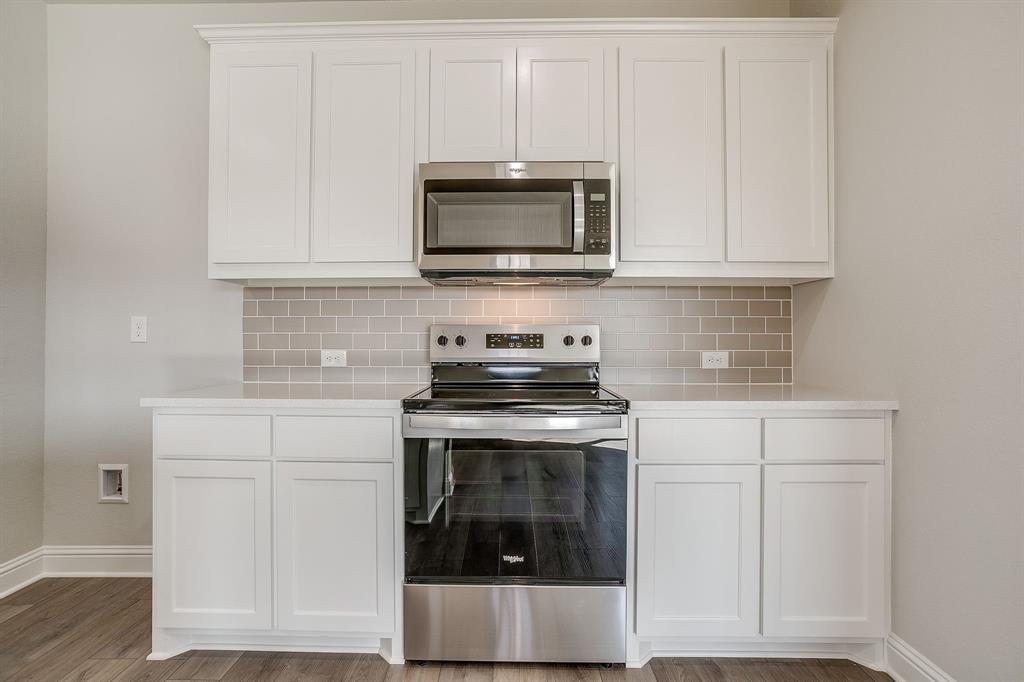 6817 Robert Reed Drive Arlington, TX 76001 - Photo 19 of 40 a kitchen with white cabinets and stainless steel appliances