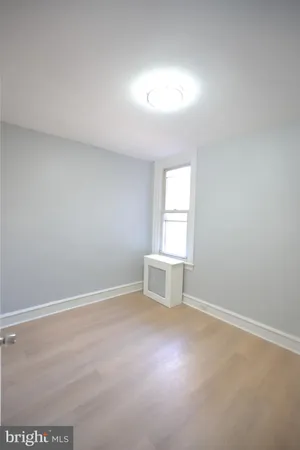 an empty room with windows and cabinet