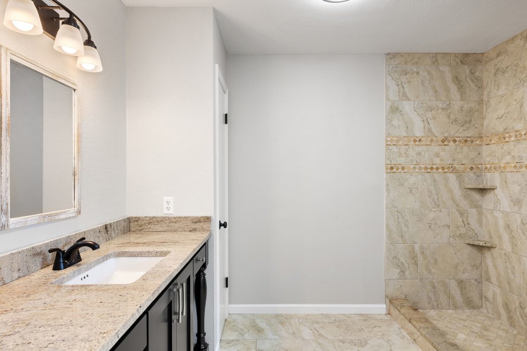2206 Jacks Pass Austin, TX 78734 - Photo 15 of 35 a bathroom with a granite countertop sink and a mirror