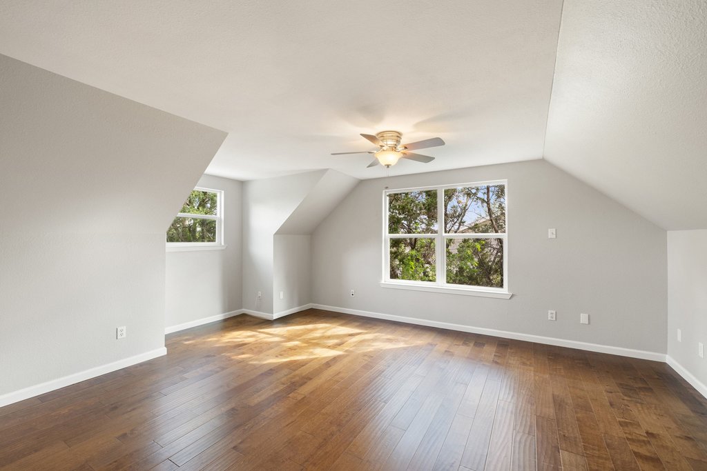 2206 Jacks Pass Austin, TX 78734 - Photo 19 of 35 an empty room with wooden floor chandelier fan and windows