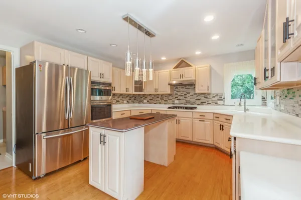 a kitchen with kitchen island granite countertop a sink appliances cabinets and counter space