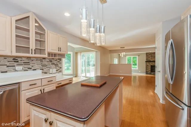a kitchen with stainless steel appliances granite countertop a sink refrigerator and cabinets