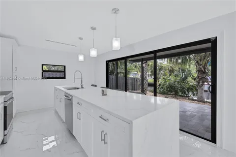 a large white kitchen with a large window