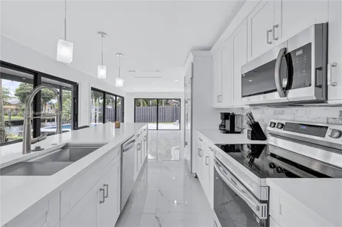 a kitchen with stainless steel appliances granite countertop a sink and a stove