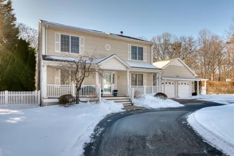 a front view of a house with a couch and a tree