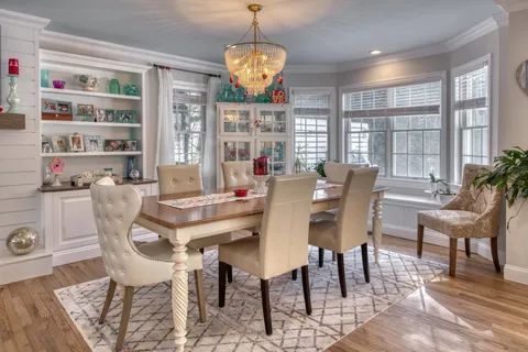 a dining room with furniture a chandelier and window