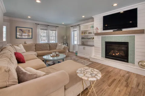 a living room with furniture a flat screen tv and a fireplace