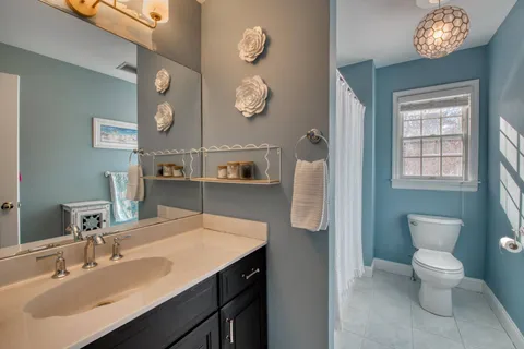 a bathroom with a sink a toilet and a mirror