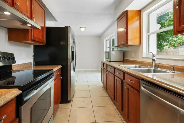 a kitchen with stainless steel appliances granite countertop a sink and a stove