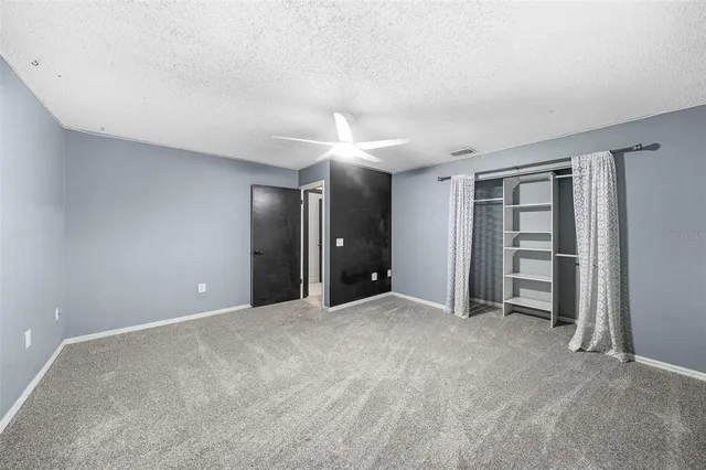 an empty room with windows and closet