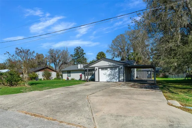 an aerial view of a house with a yard and green space
