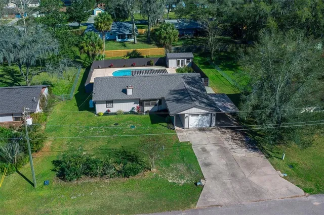 an aerial view of a house with swimming pool a yard and outdoor seating