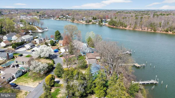 an aerial view of lake and residential houses with outdoor space