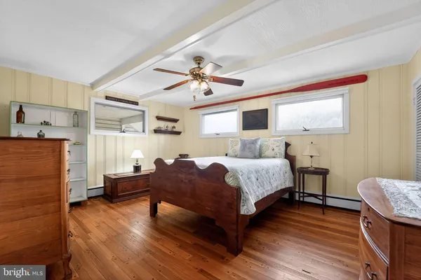 a bedroom with bed and wooden floor