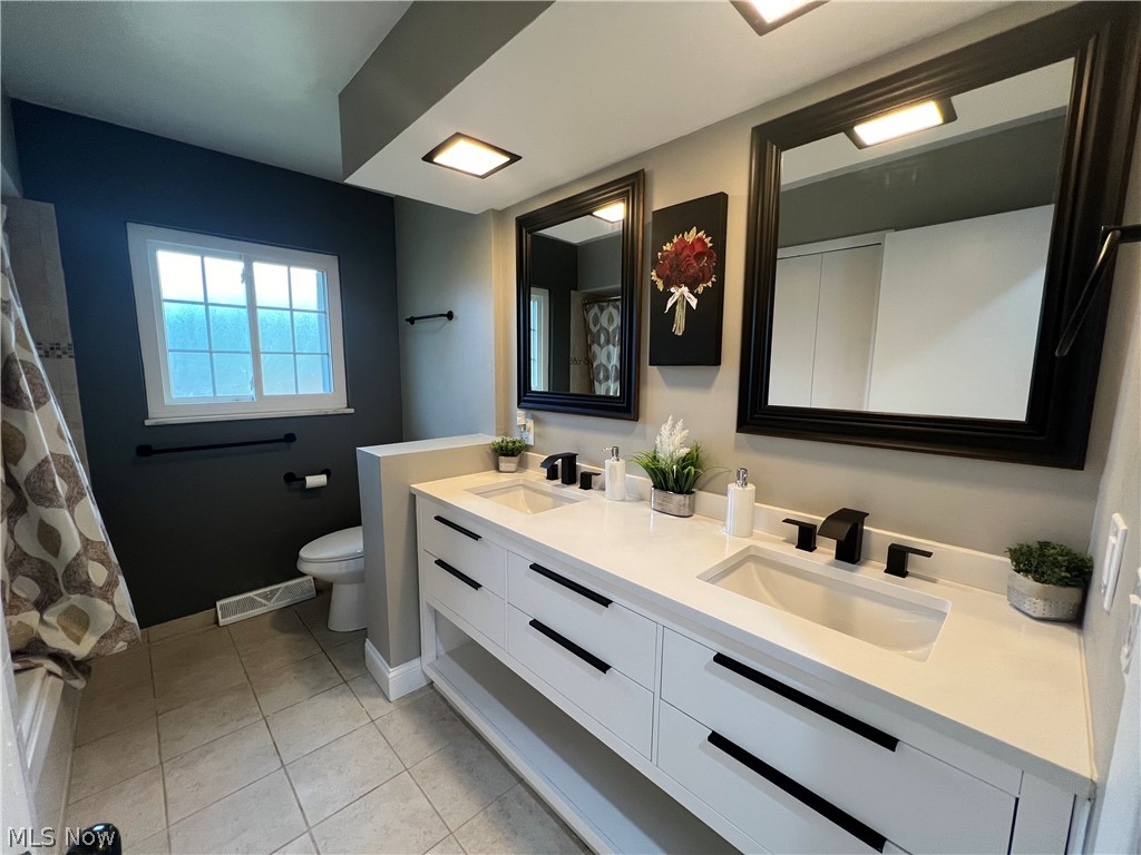 7475 Selwick Drive Parma, OH 44129 - Photo 19 of 29 Bathroom with tile floors, double vanity, and toilet