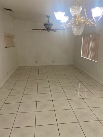 a view of an empty room with a chandelier fan