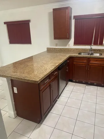 a kitchen with a sink a stove top oven and cabinets