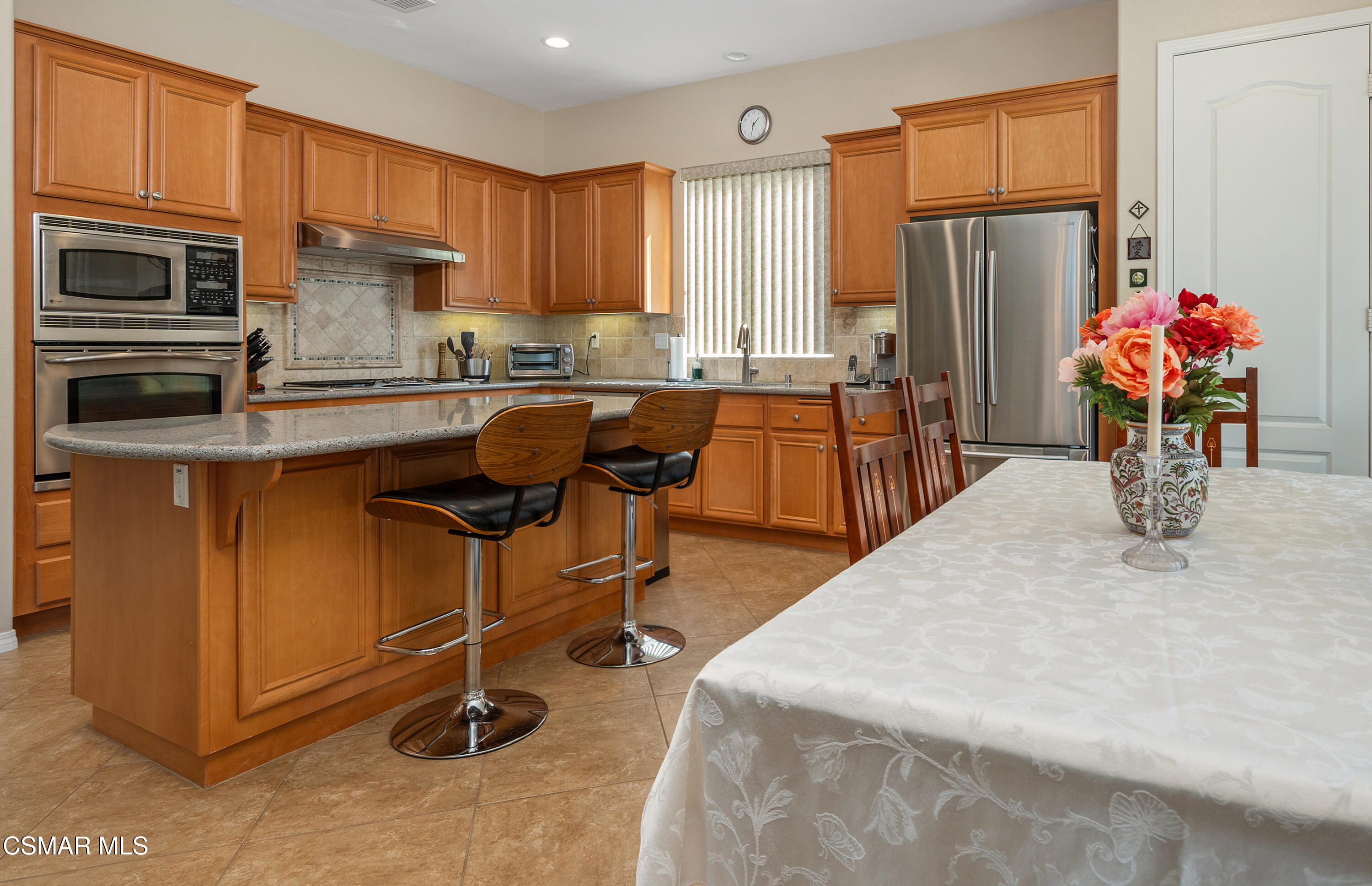 6835 Blue Ridge Way Moorpark, CA 93021 - Photo 22 of 39 a kitchen with stainless steel appliances granite countertop a refrigerator a sink dishwasher a dining table and chairs with wooden floor