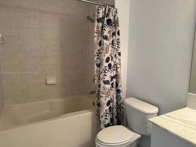 a white toilet sitting next to a bath tub