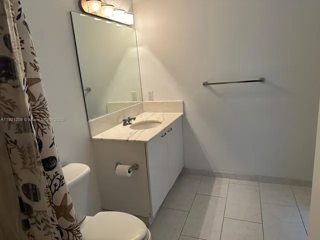 a bathroom with a sink and mirror with toilet