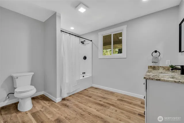 a bathroom with a granite countertop toilet and a sink