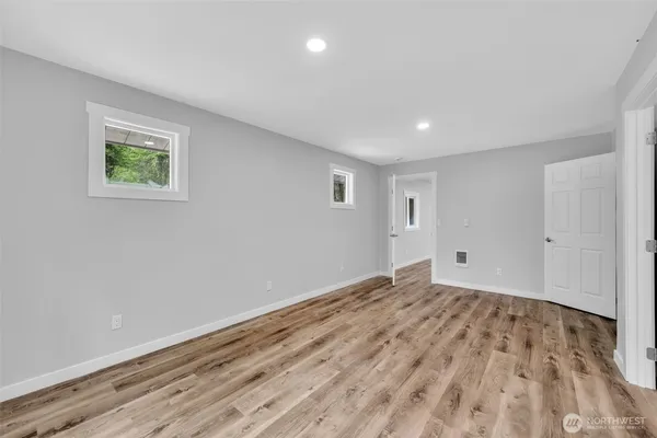 a view of empty room with wooden floor