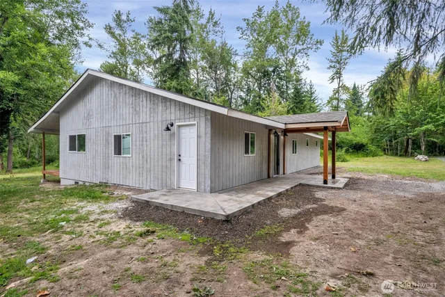 a view of a house with backyard and trees