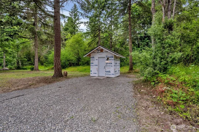 a wooden house with trees in the background