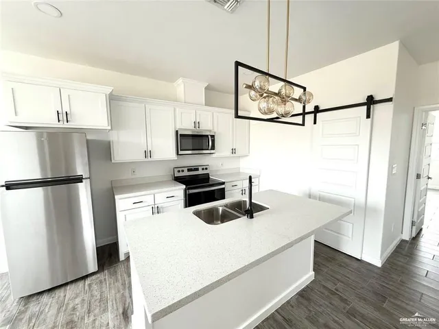 a kitchen with appliances a counter space and cabinets