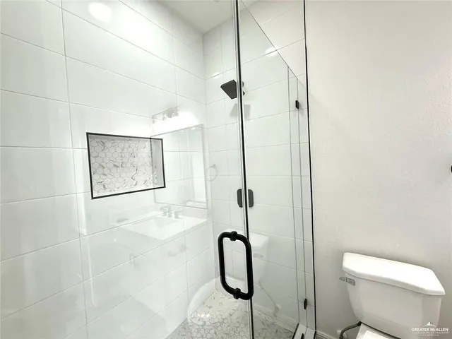 a bathroom with a shower toilet and sink