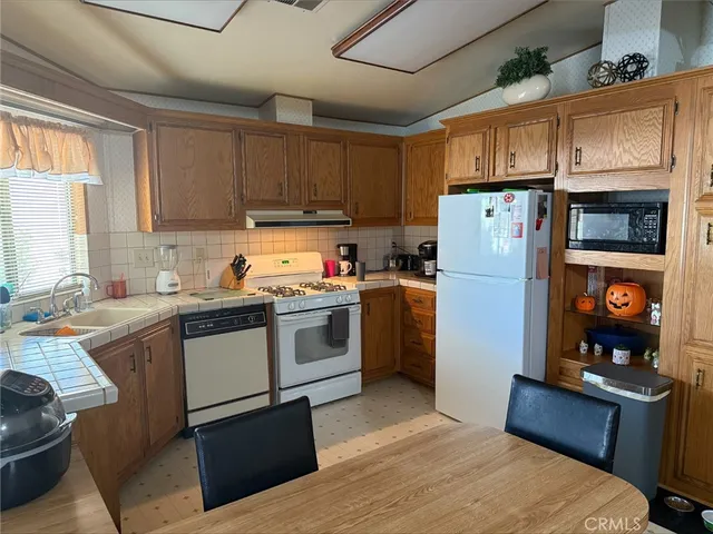 a kitchen with a refrigerator and a stove top oven