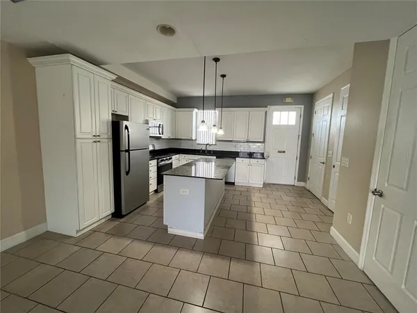 a kitchen with stainless steel appliances granite countertop a refrigerator and a stove top oven