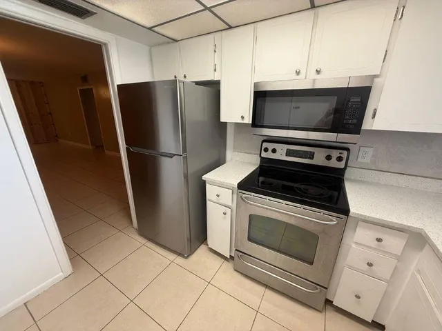 a view of an empty room with closet and a window