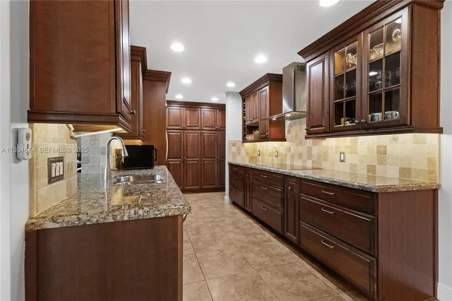 a kitchen with kitchen island granite countertop a sink and refrigerator