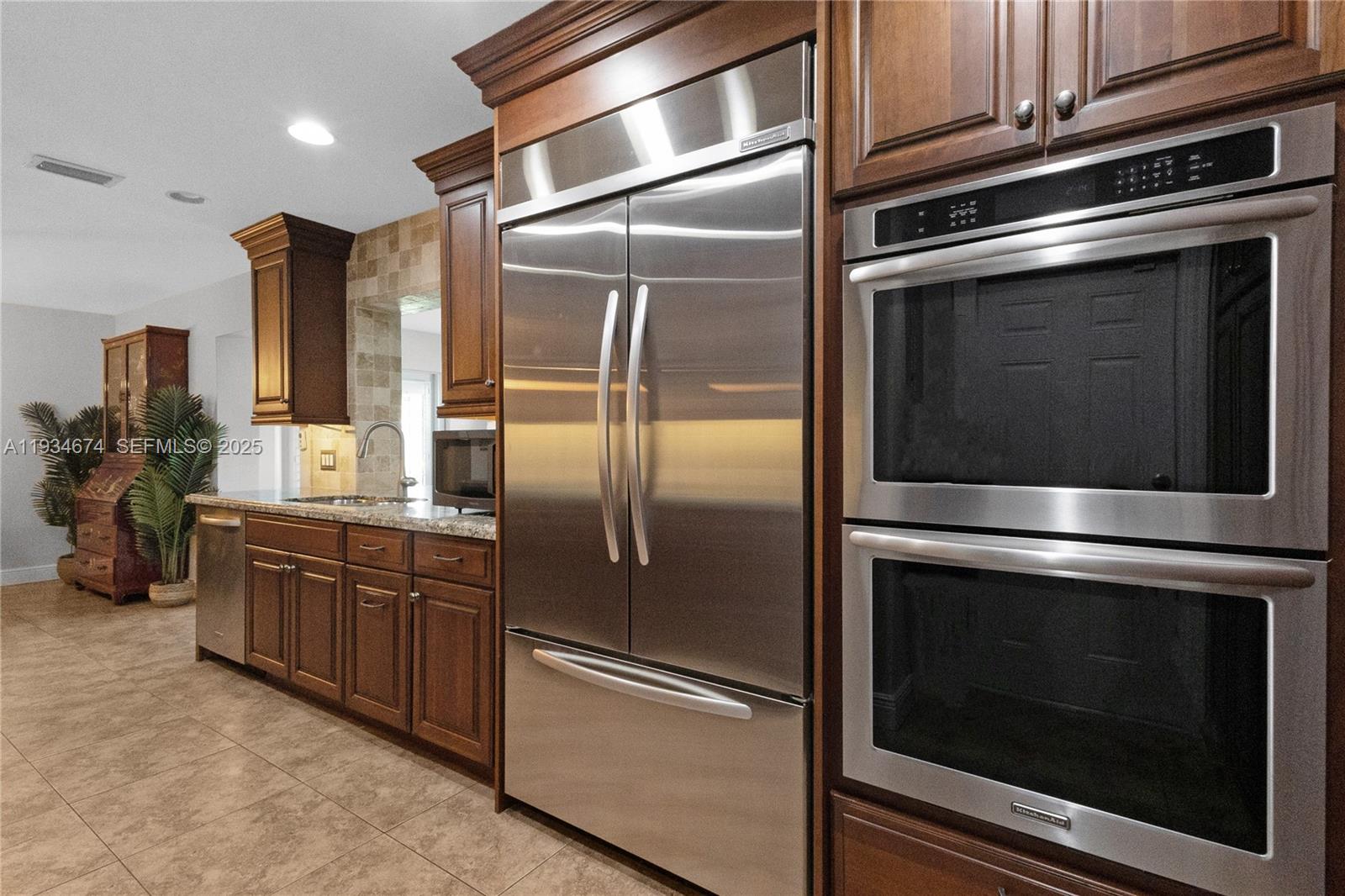 3401 Northeast 21st Avenue Lighthouse Point, FL 33064 - Photo 15 of 38 a kitchen with granite countertop stainless steel appliances and wooden cabinets