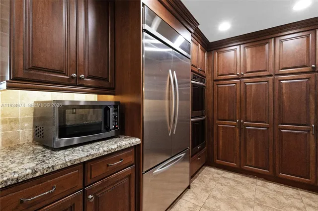 a metallic refrigerator freezer sitting in a kitchen