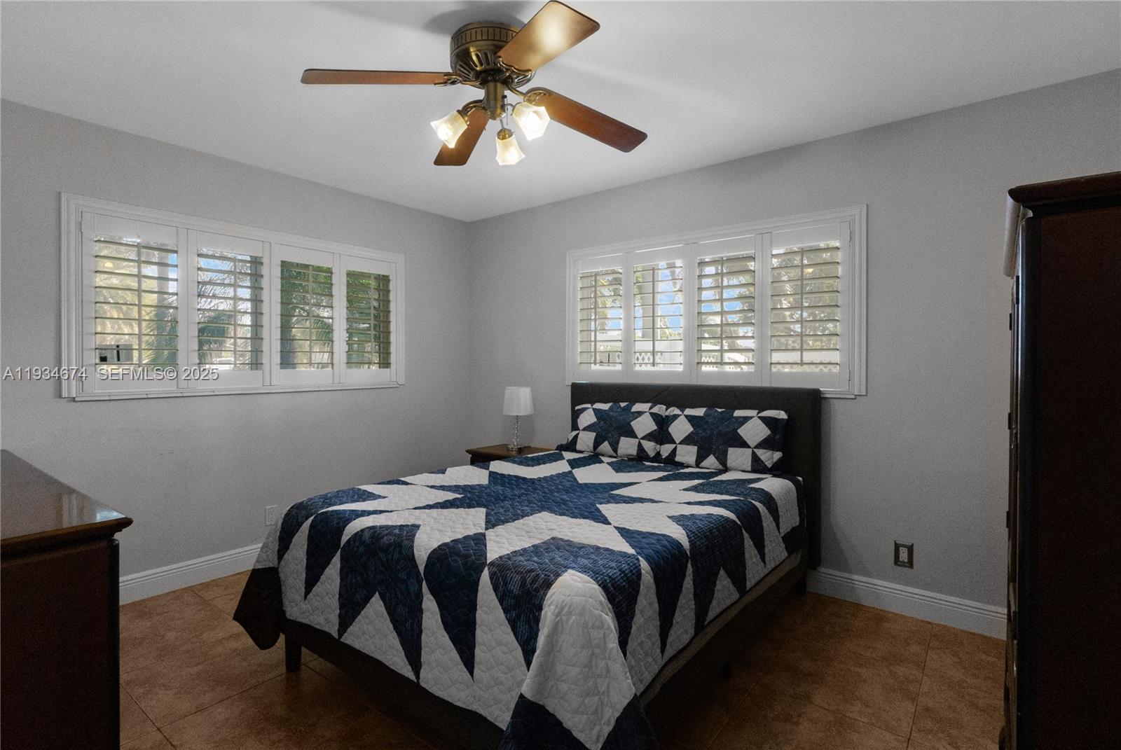 3401 Northeast 21st Avenue Lighthouse Point, FL 33064 - Photo 23 of 38 a bedroom with a bed a window and a chandelier