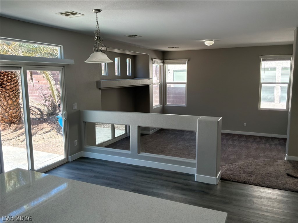 9041 Rendon Street Las Vegas, NV 89143 - Photo 7 of 34 A half wall with display cutouts bridges the modern kitchen area and the carpeted living room.