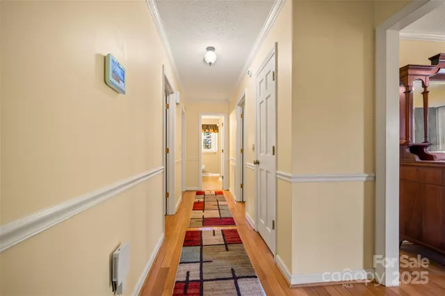 a view of a hallway with white walls and refrigerator