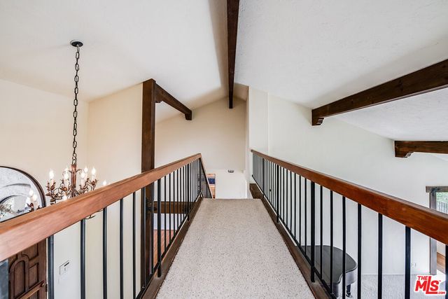 a view of staircase with railing and a chandelier